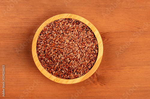 An overhead photo of flax seeds, shot from the top on a dark rustic wooden background with copy space
