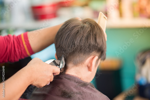 Foto Little boy sitting for hair cut at barber shop