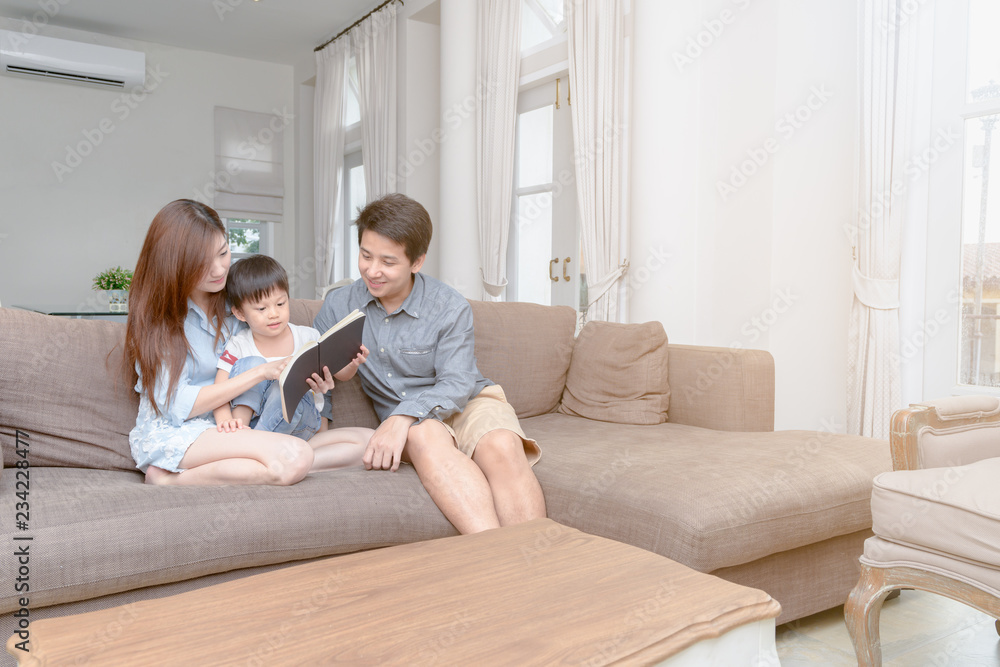 Happy asian family reading storybook at home Happy asian family reading storybook at home