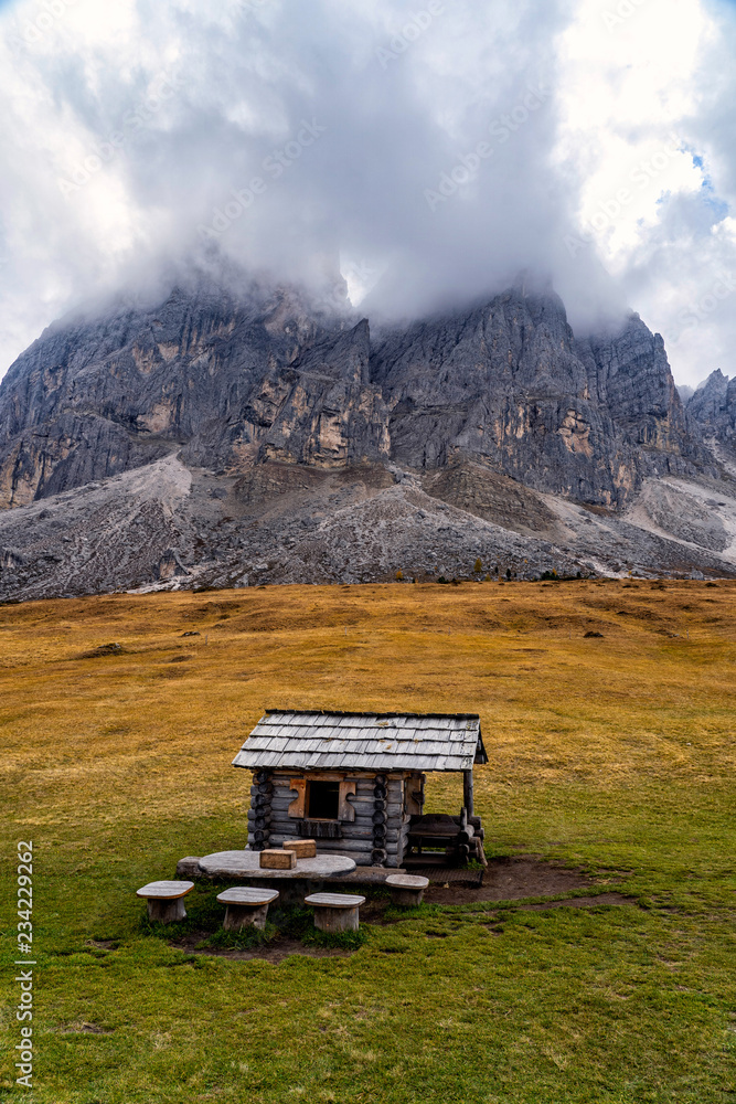 Obraz premium Wooden shed on a grassy meadow in a mountains.