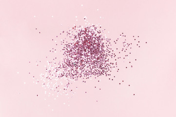 Pink holographic glitter confetti in the form of stars on pink background Flat lay top view copy space. Festive holiday pastel backdrop. Birthday, congratulations, Christmas, New Year