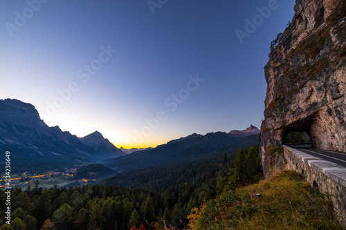 Early morning view of beautiful Dolomites mountains in Italian Alps with mountain road and tunnel.