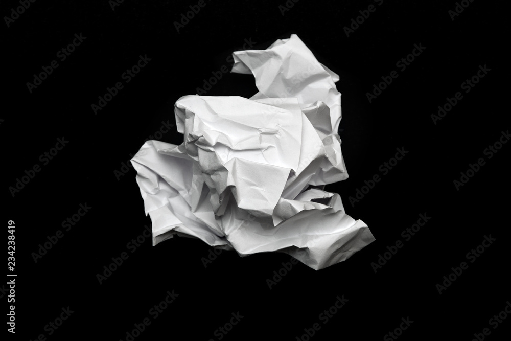 crumpled square lump of white paper on a black background crumpled square lump of white paper on a black background
