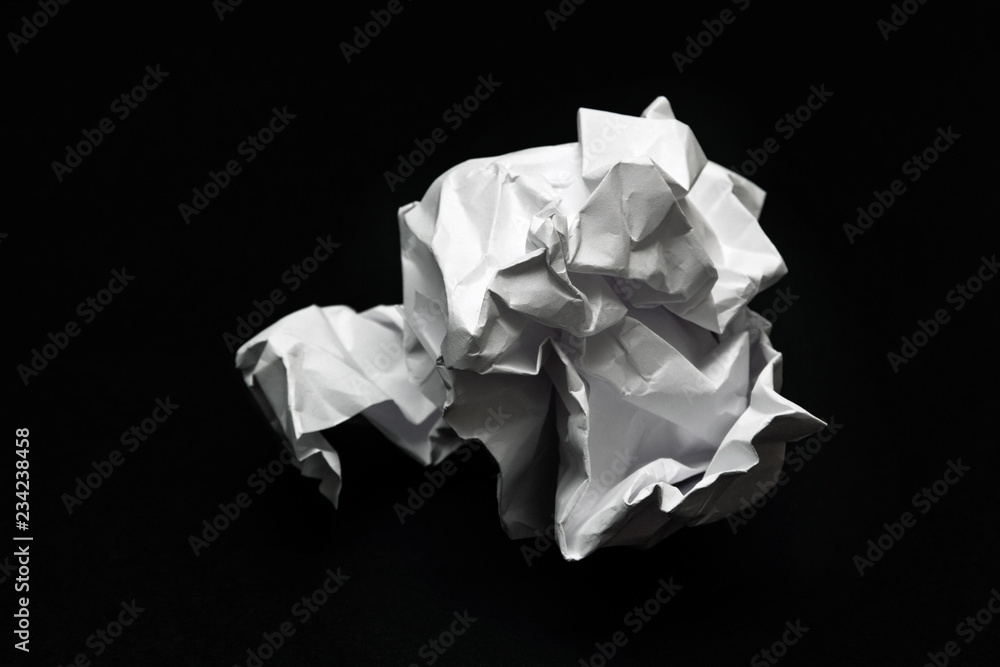 crumpled square lump of white paper on a black background crumpled square lump of white paper on a black background