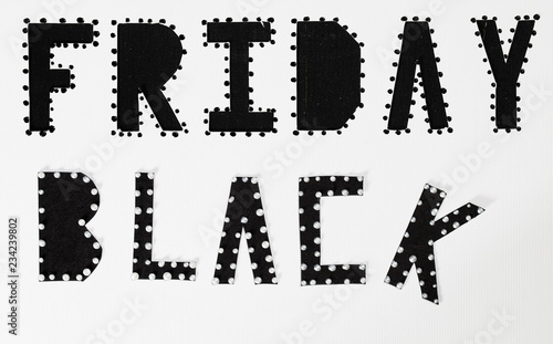 Words BLACK FRIDAY are cut out from black carton paper.