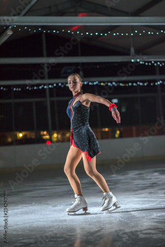 We can see the ice skater's elegant movement on the ice. She is having a performance.
