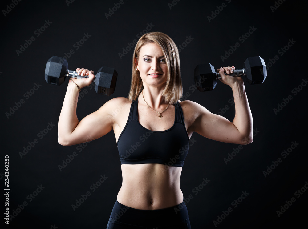 Sport nice pretty girl is doing training fitness lifting weight on the black background Sport nice pretty girl is doing training fitness lifting weight on the black background