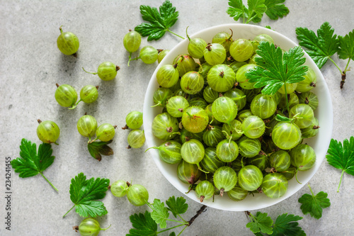 Green fresh gooseberry fruits in a bowl, top view