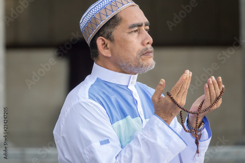 Middle age muslim man praying at mosque. © tuahlensa