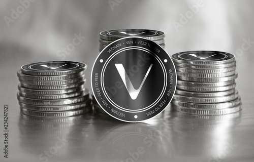 Vechain (VEN) digital crypto currency. Stack of black and silver coins. Cyber money. photo