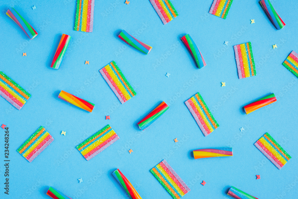 pattern wuth rainbow candies on a blue background, top view flat lay pattern wuth rainbow candies on a blue background, top view flat lay