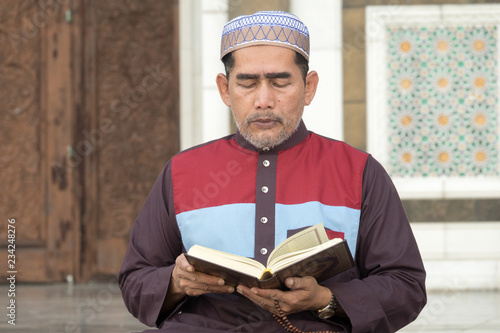 Middle age muslim man praying at mosque. photo