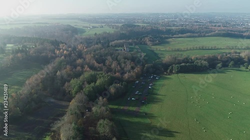 Aerial footage flying towards the Hunting lodge at Chatelherault country park over woodland and a car park. photo