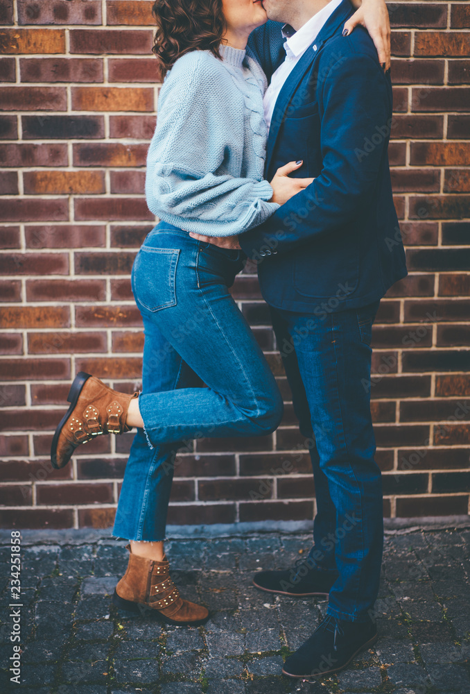 Stylish couple kissing near the brick wall Stylish couple kissing near the brick wall