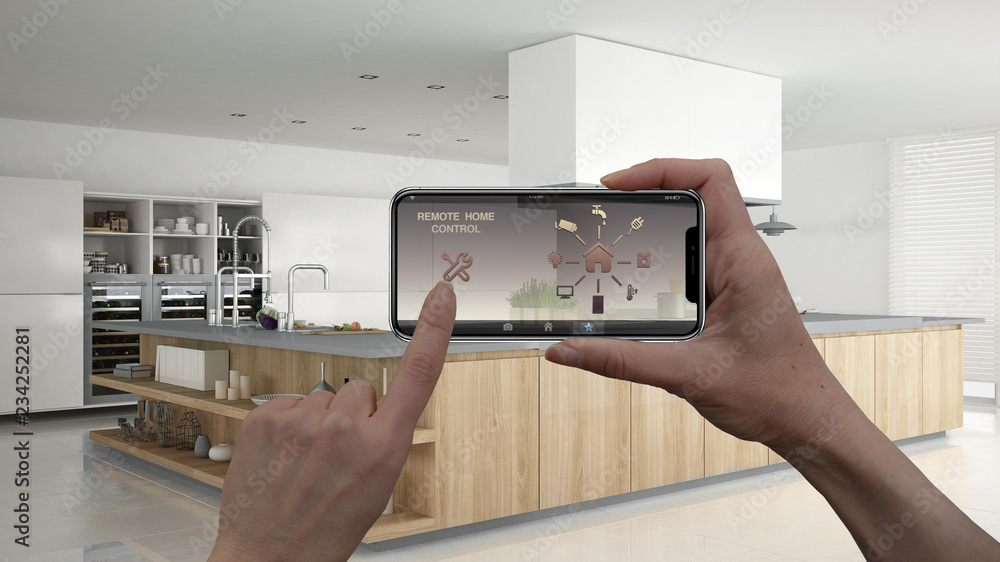 Remote home control system on a digital smart phone tablet. Device with app icons. Interior of professional modern wooden kitchen in the background, architecture design Remote home control system on a digital smart phone tablet. Device with app icons. Interior of professional modern wooden kitchen in the background, architecture design