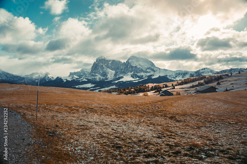  Beautiful view autumn sunrise scenery with yellow larches and small alpine building and Odle - Geisler mountain group on background. Alpe di Siusi (Seiser Alm), Dolomite Alps, Italy. photo