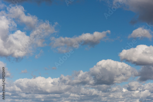 Fototapeta Naklejka Na Ścianę i Meble -  Beautiful white and grey fluffy clouds soar over a deep blue background. Cloudscape with autumn dark storm clouds moving fast over blue sky day.