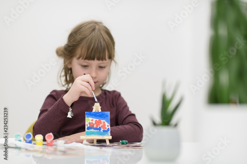 little girl painting on canvas