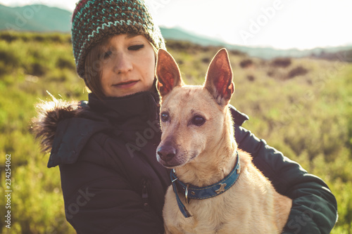 Portrait of a young woman with her dog in the countryside