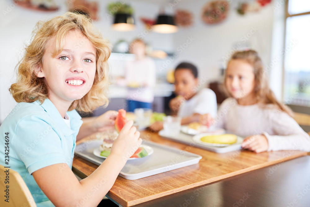 Kinder essen in Kantine einer Grundschule Mittagessen