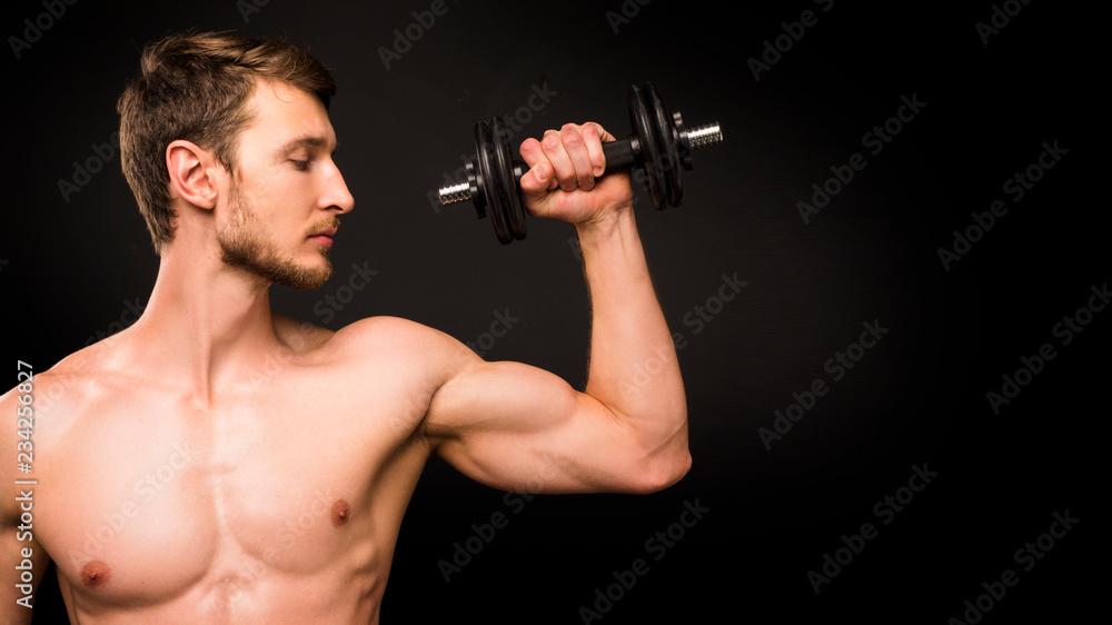 Strong Muscular man with naked torso abs working out in gym doing exercises with dumbell
