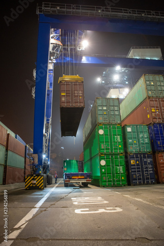 Photography industrial port with containers and cranes at night time