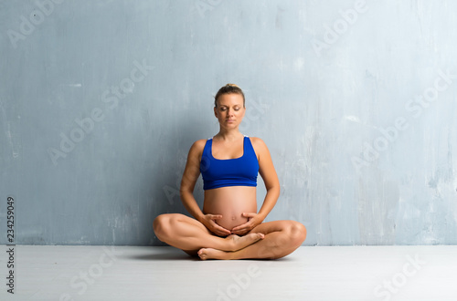 Blonde pregnant woman doing yoga