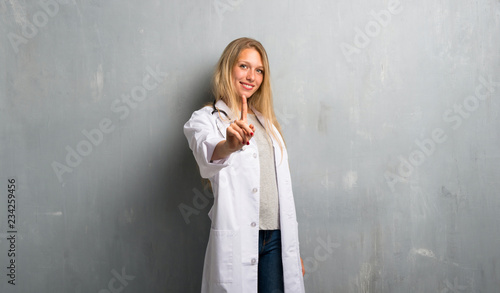 Young doctor woman showing and lifting a finger in sign of the best © luismolinero