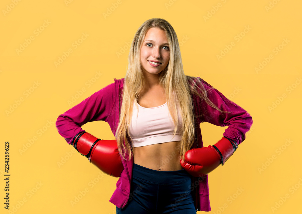 Pretty sport woman with boxing gloves on yellow background Pretty sport woman with boxing gloves on yellow background