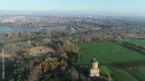 Aerial footage flying away from Hamilton Mausoleum, with M74 motorway and townscape of Motherwell. photo