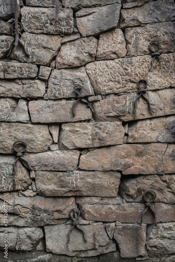 Old rock wall with neatly fitted stones and iron reinforcement loops Old rock wall with neatly fitted stones and iron reinforcement loops