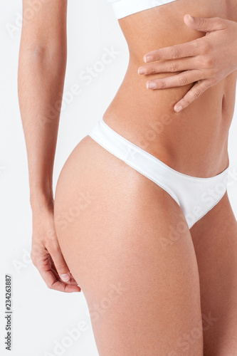 Beautiful body of slender girl close-up. Isolated on white © Mirrorstudio