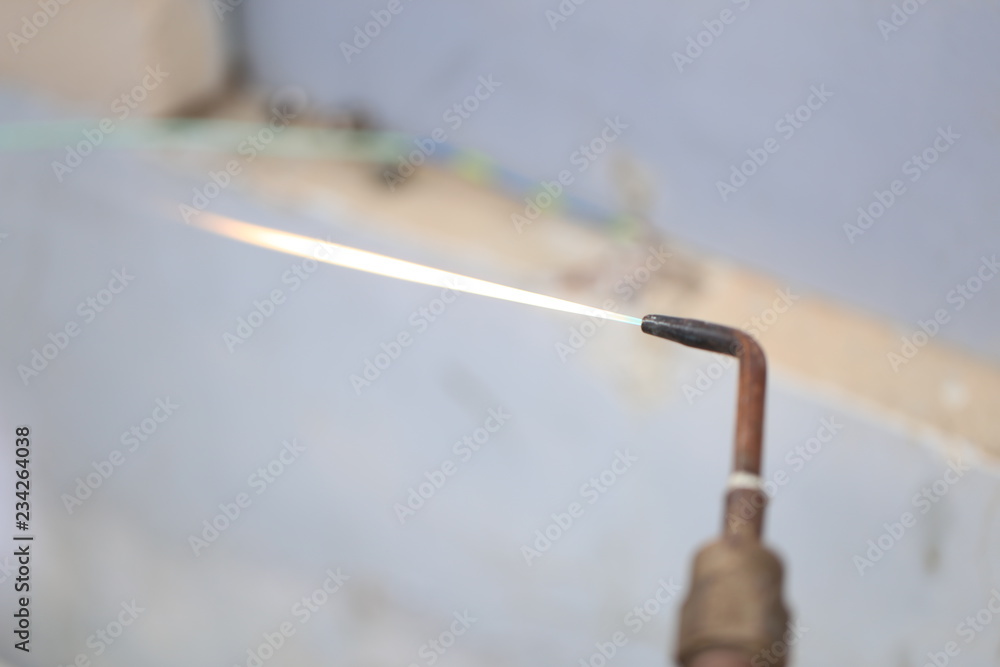 Technician are soldering a coil with copper in order to fix leakage of air compressor. This is a oil and piping problem of air-conditioner unit. Technician are soldering a coil with copper in order to fix leakage of air compressor. This is a oil and piping problem of air-conditioner unit.