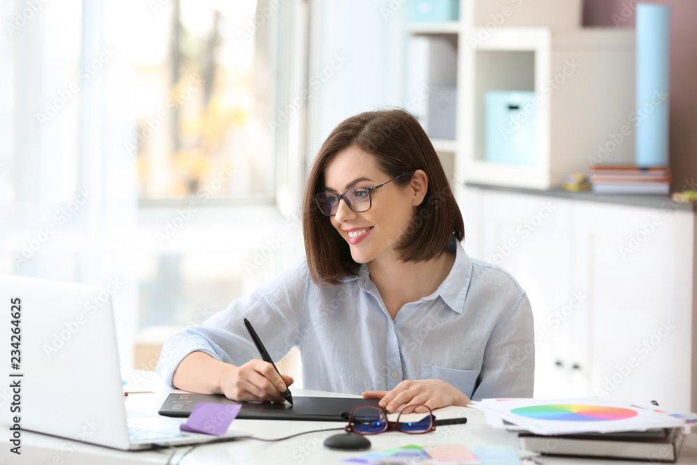 Beautiful young designer working in office Beautiful young designer working in office