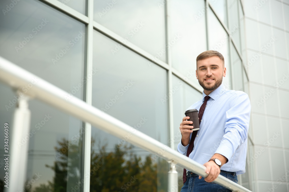 Businessman with cup of coffee outdoors
