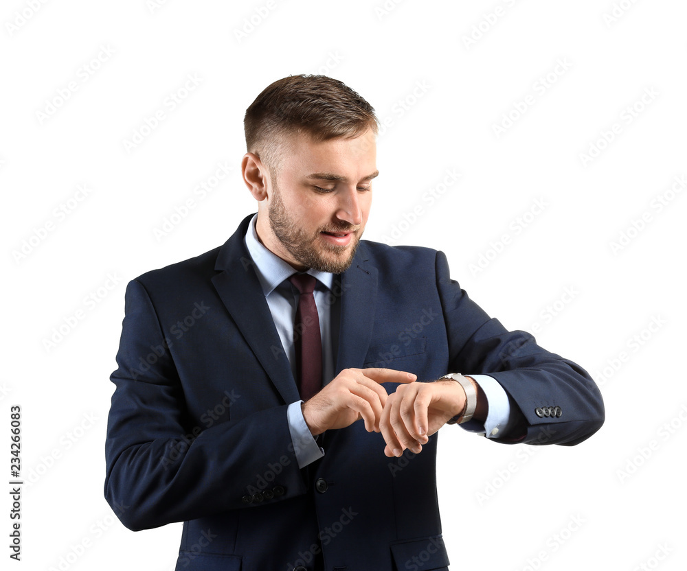 Young businessman looking at watch on white background Young businessman looking at watch on white background