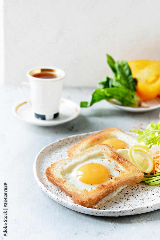 American breakfast on a plate with fried eggs in toast, with tomatoes, fresh daikon, carrots, arugula and espresso. Fried egg for traditional breakfast close up shoot American breakfast on a plate with fried eggs in toast, with tomatoes, fresh daikon, carrots, arugula and espresso. Fried egg for traditional breakfast close up shoot