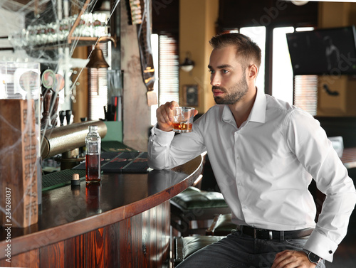 Young man drinking whiskey ...