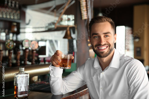 Young man drinking whiskey ...