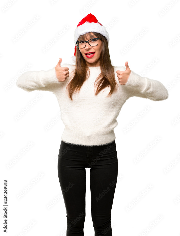 Girl with celebrating the christmas holidays giving a thumbs up gesture and smiling because has had success on isolated white background Girl with celebrating the christmas holidays giving a thumbs up gesture and smiling because has had success on isolated white background