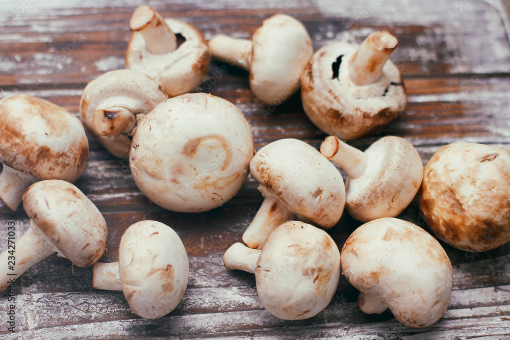 Fresh raw champignon mushrooms on wooden table. Cooking process. Modern kitchen. Fresh raw champignon mushrooms on wooden table. Cooking process. Modern kitchen.