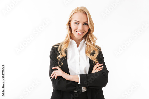 Photo of attractive businesswoman wearing office suit standing with arms crossed, isolated over white background in studio