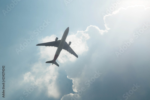 Airplane in the sky. Passenger aircraft of medium size taking off short after landing in airport. Upwards view of bottom side of commercial airplane.