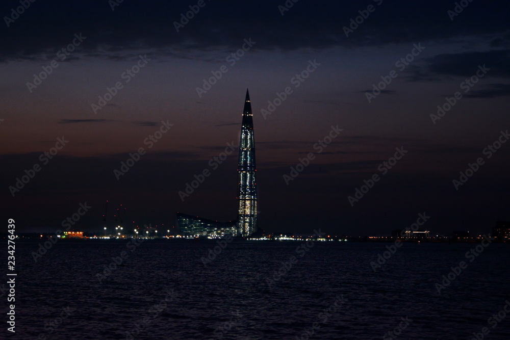 Cityscape – dominate high luminous skyscraper on shore of the Gulf of night