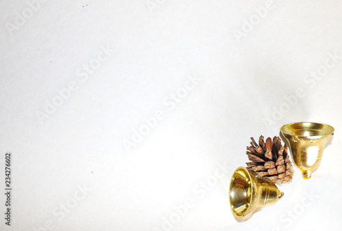 Christmas and new year's composition for invitations, greetings, cards. Golden bells and beautiful fir cones on a white background, with space for text.