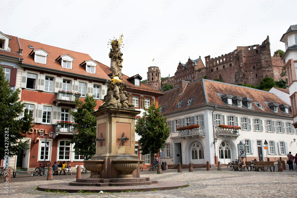 German and foreigner travelers people walking and visit madonna statue at the corn market square in Heidelberg, Germany