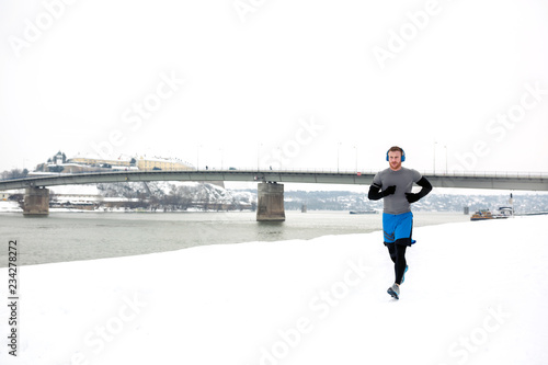 Jogging on the river embankment covered with snow