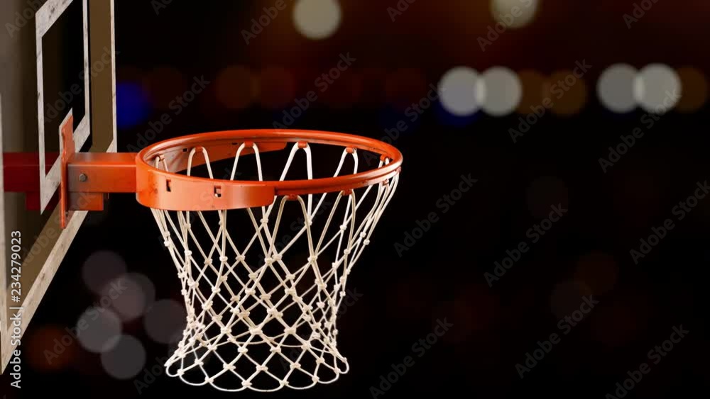 A throw in a basketball ring on the background of yellow spotlights A throw in a basketball ring on the background of yellow spotlights