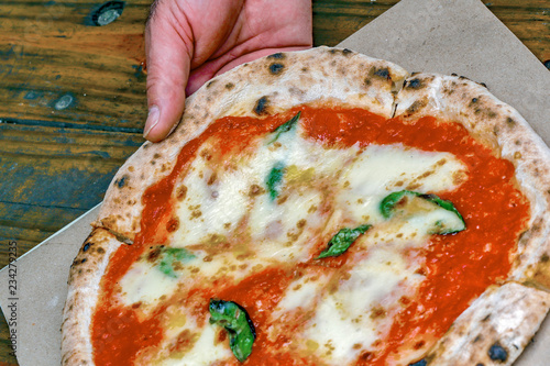 Pizza Margherita on rustic wooden table photo