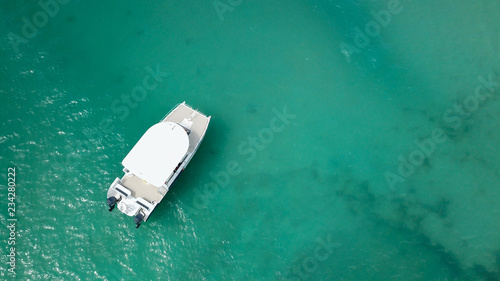 Boats on the sea. The boat is floating on the emerald clear sea between coral reefs. Aerial view